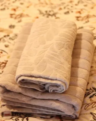 a pile of towels sitting on top of a bed at 3 Bedrooms Flat in Central Edinburgh Old Town Sleeps 6 in Edinburgh