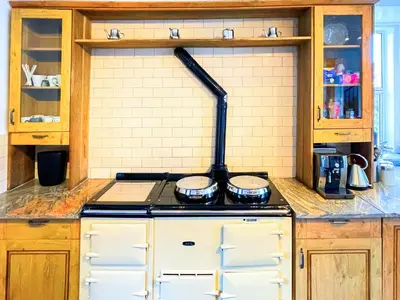 a kitchen with a stove top oven in a kitchen at Colzium Farmhouse in Blitterlees