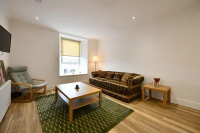 a living room with a couch and a table at Troon Portland Apt A in Troon