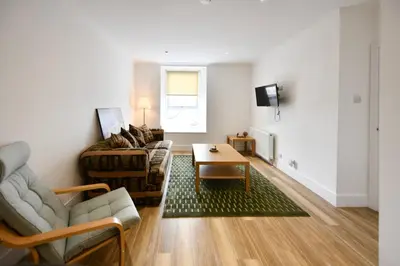 a living room with a couch and a table at Troon Portland Apt B in Troon