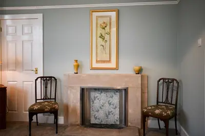 a living room with two chairs and a fireplace at Dunvegan Apartment Troon in Troon