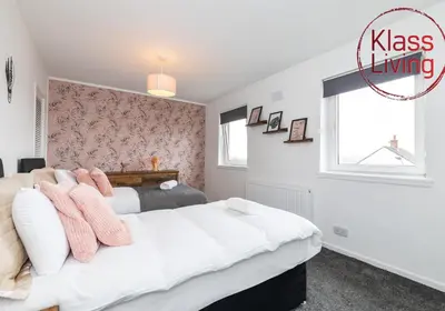 a bedroom with two beds and a window at Aitkenhead house by Klass Living in Coatbridge
