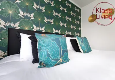 a bedroom with a bed with blue and white pillows at Aitkenhead house by Klass Living in Coatbridge