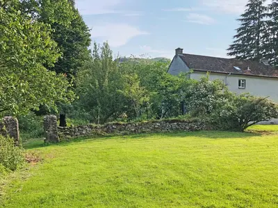 a stone wall in front of a house at Bridge Park in Killin
