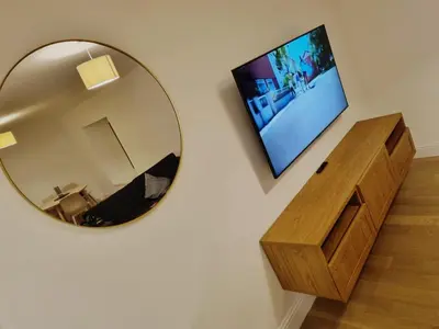 a mirror hanging on a wall next to a bathroom at Oban Lorne Apartment in Oban