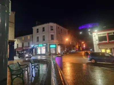 a city street at night with cars driving down the street at Oban Lorne Apartment in Oban