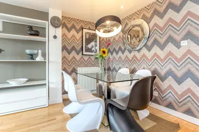 a dining room with a glass table and chairs at SECC Hydro Executive 7 Apartment in Glasgow