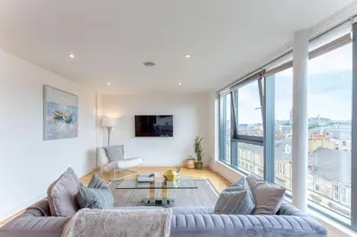 a living room with a couch and a large window at SECC Hydro Executive 7 Apartment in Glasgow
