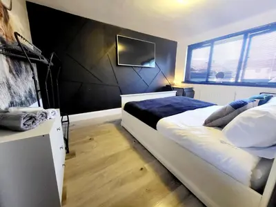 a bedroom with a bed and a tv on the wall at Scottish Nest in the heart of East Kilbride 10mins from Hairmyres Hospital in East Kilbride