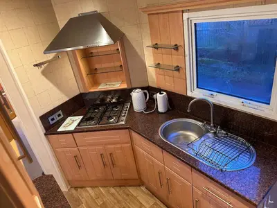 a small kitchen with a sink and a stove at Atlas 2 Bedroom Caravan - Located in Uddingston, Glasgow at Maryville Caravan Site in Uddingston