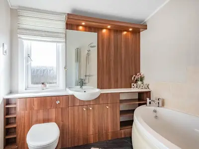 a bathroom with a toilet and a sink and a tub at Oakwood Lodge in Lochwinnoch