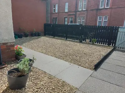 a patio with a fence and potted plants at The Relish - ground floor flat in Largs in Largs