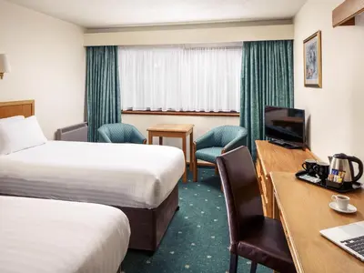 a hotel room with two beds and a desk at Mercure Livingston Hotel in Livingston