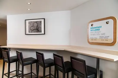 a bar with black chairs and a sign on the wall at Holiday Inn Express Stirling by IHG in Stirling