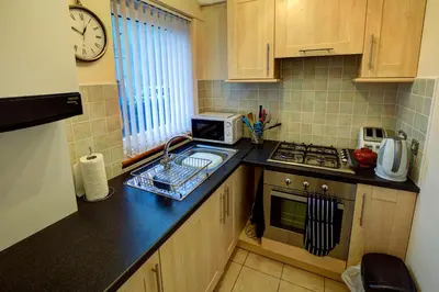 a small kitchen with a sink and a microwave at Cedars Apartment in Kirn