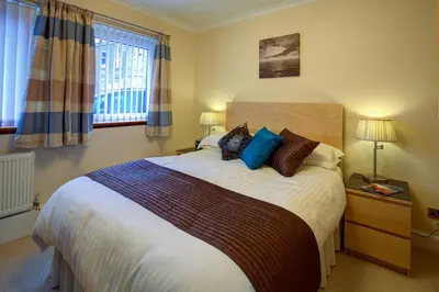 a bedroom with a large bed with blue pillows at Cedars Apartment in Kirn