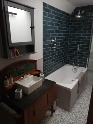 a bathroom with a tub and a sink and a bath tub at Borrowmoss Bothy, Charming & Characterful property, Wigtown in Wigtown