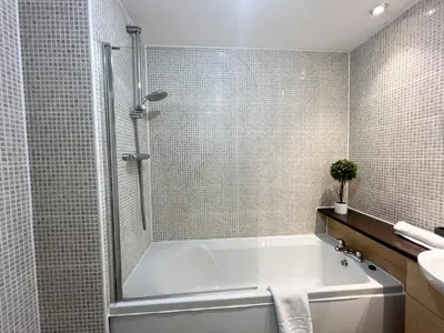 a bathroom with a white tub and a sink at Duplex Apartment in Glasgow in Glasgow