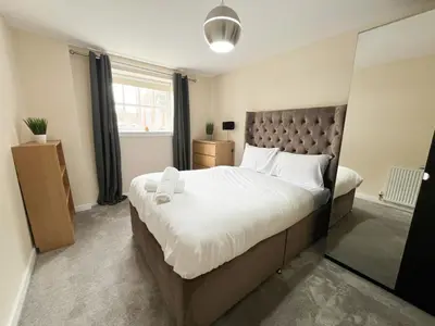 a bedroom with a large bed and a window at Duplex Apartment in Glasgow in Glasgow