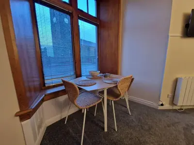 a table and chairs in a room with a window at The Old Post Office House in Perth