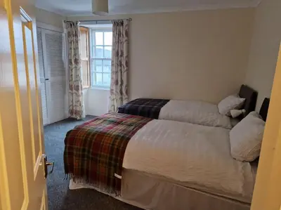 a bedroom with a bed and a window at The Old Post Office House in Perth