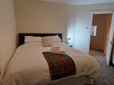 a bedroom with a large bed with towels on it at The Old Post Office House in Perth