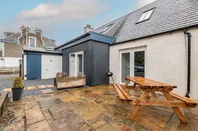 a wooden picnic table in front of a house at No7 Drummond Street, 2 bedrooms, Comrie in Comrie
