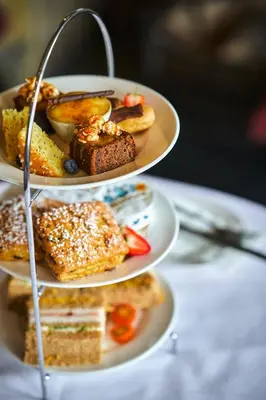 a three tiered plate of food on a table at Stirling Highland Hotel- Part of the Cairn Collection in Stirling