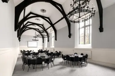 a dining room with black tables and chairs and chandeliers at Stirling Highland Hotel- Part of the Cairn Collection in Stirling