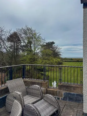 a balcony with two chairs and a fence at Lochgreen House Hotel & Spa in Loans