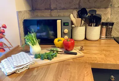 a cutting board with fruits and vegetables on a counter at Holmlea Cottage in Moffat