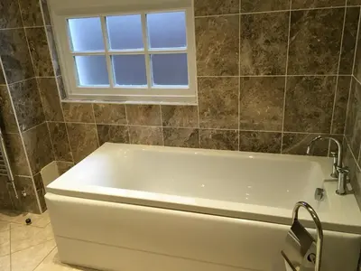 a white bath tub in a bathroom with a window at Cottage in Ayr