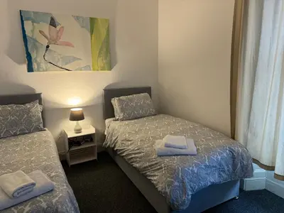 a small bedroom with two beds and a lamp at 140 MAIN ST GROUND LEFT in Largs
