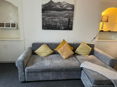 a grey couch with yellow pillows in a living room at 140 MAIN ST GROUND LEFT in Largs