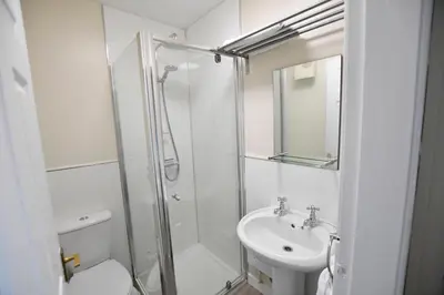 a white bathroom with a shower and a sink at Argyll House The Byre in Salen