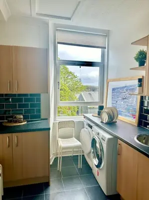 a kitchen with a washing machine and a window at Dumbarton cosy home, Loch Lomond in Dumbarton