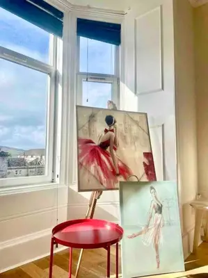 a painting and a red stool in front of a window at Dumbarton cosy home, Loch Lomond in Dumbarton