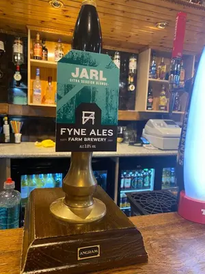 a bottle of wine on a stand in a bar at Kingarth Hotel in Kilchattan