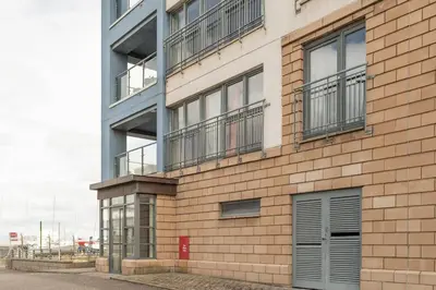 a brick building with balconies on the side of it at Calming Sea View City Apartment in Edinburgh
