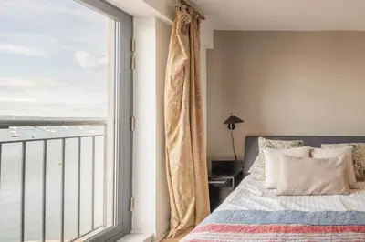 a bedroom with a bed and a large window at Calming Sea View City Apartment in Edinburgh