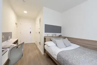 a white bedroom with a bed and a desk at For Students Only St Mungo's in Glasgow in Glasgow