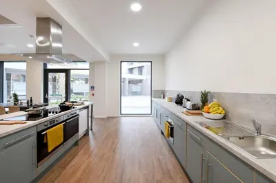 a kitchen with stainless steel appliances and wooden floors at For Students Only St Mungo's in Glasgow in Glasgow