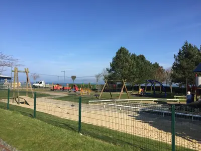a park with a playground with people playing in it at Lakeview Guest House in Stranraer