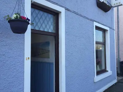 a blue building with a door and a window at Lakeview Guest House in Stranraer
