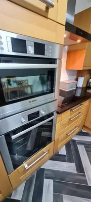 a kitchen with two ovens in a wooden cabinet at Stylish home in Linlithgow Near Edinburgh Airport Free parking Free WiFi in Linlithgow
