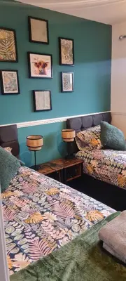 a room with two beds and pictures on the wall at Stylish home in Linlithgow Near Edinburgh Airport Free parking Free WiFi in Linlithgow