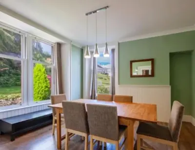 a dining room with green walls and a wooden table and chairs at Room 1, Loch Etive House, Connel near Oban in Connel