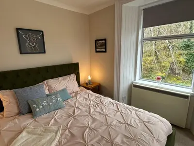 a bedroom with a large bed with a window at Room 1, Loch Etive House, Connel near Oban in Connel
