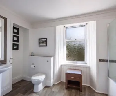a white bathroom with a toilet and a window at Room 1, Loch Etive House, Connel near Oban in Connel