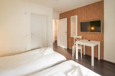 a bedroom with two beds and a table and a tv at The Saddlers House - best price per bed in Bowmore